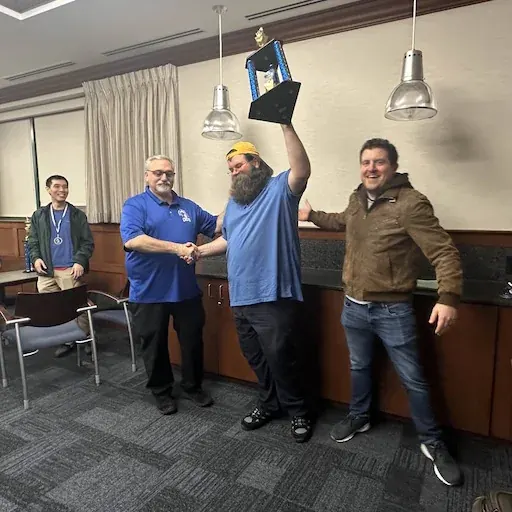 Matthew Freeman holding a chess championship trophy